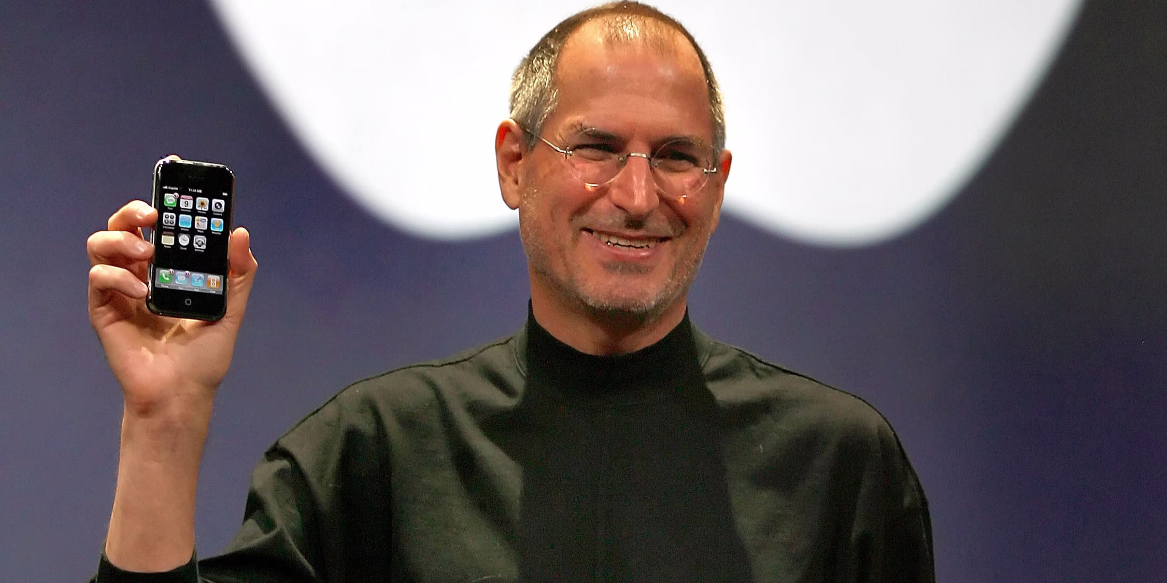 Steve Jobs holding the original iPhone